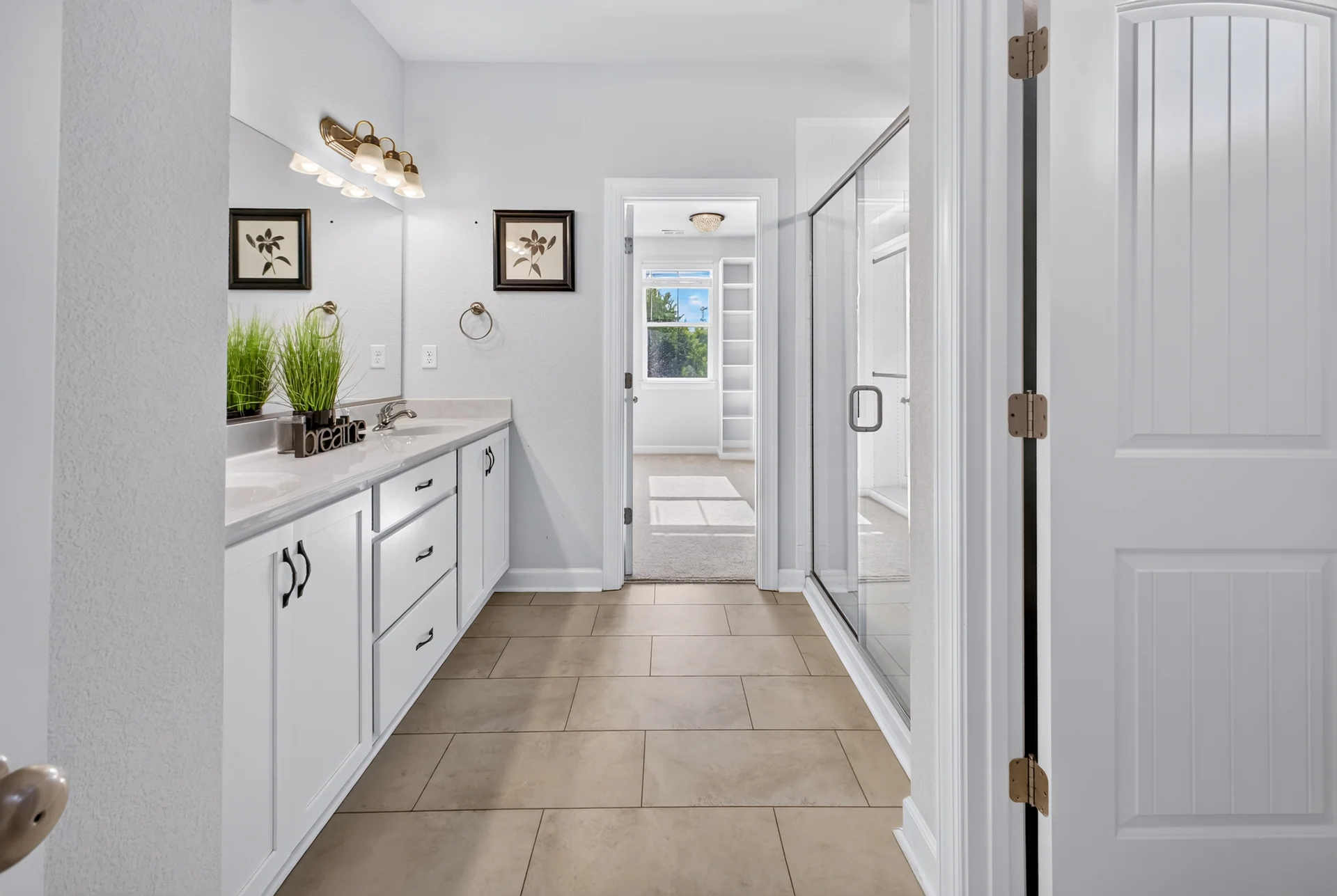 Bathroom with a long white vanity and tiled floor