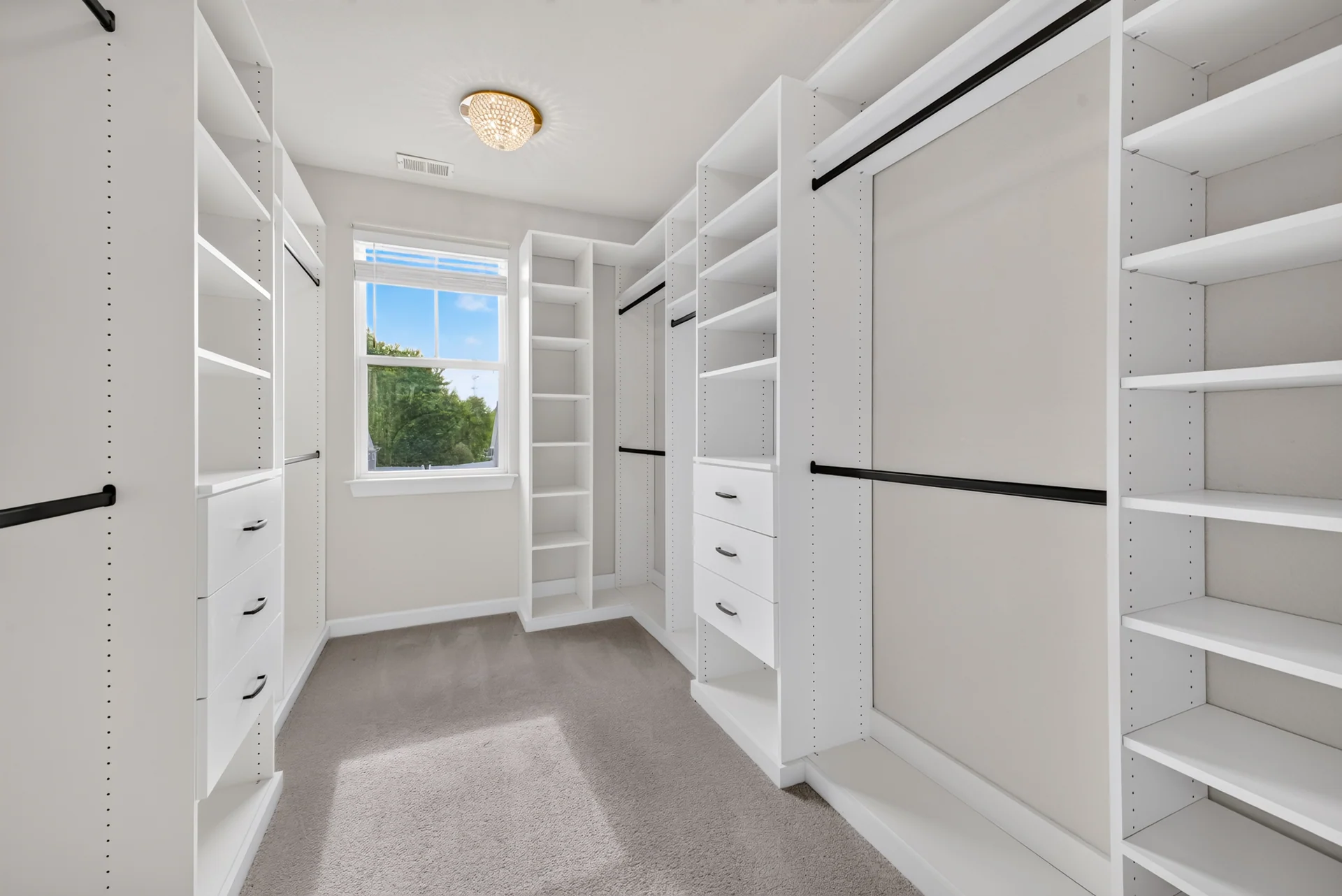 Walk-in closet with built-in white shelves and hanging rails