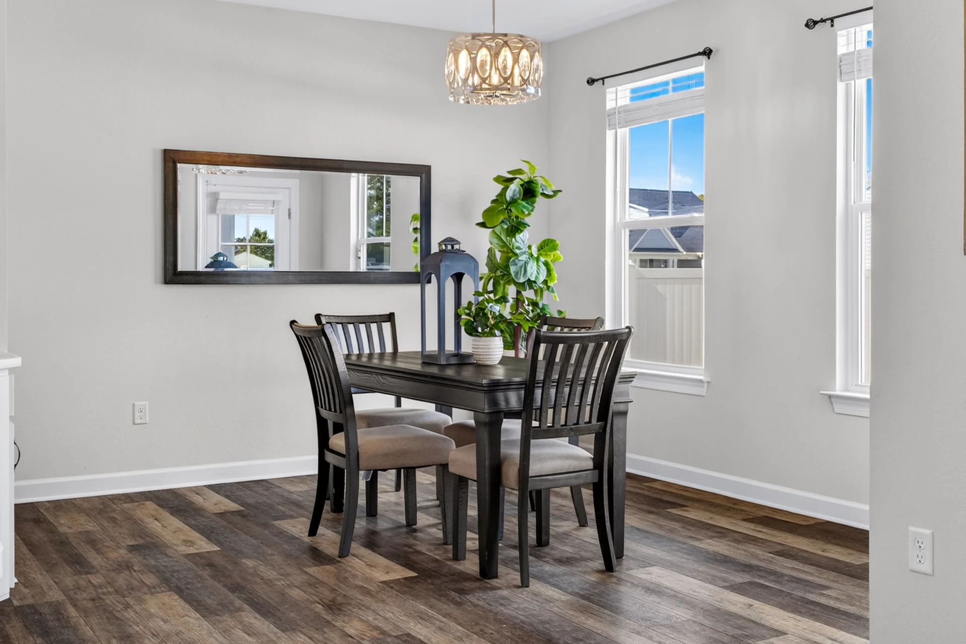 Dining room with a dark table, chandelier, and hardwood floor
