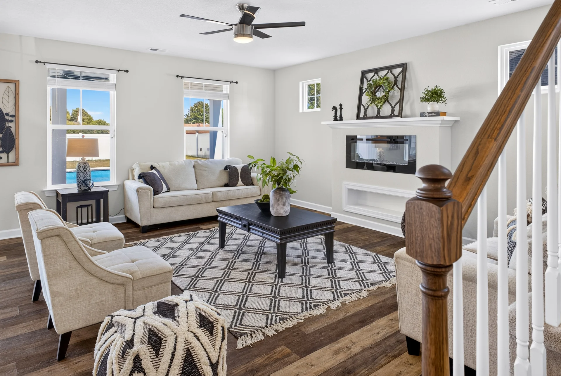 Living room with a fireplace, patterned rug, and staircase