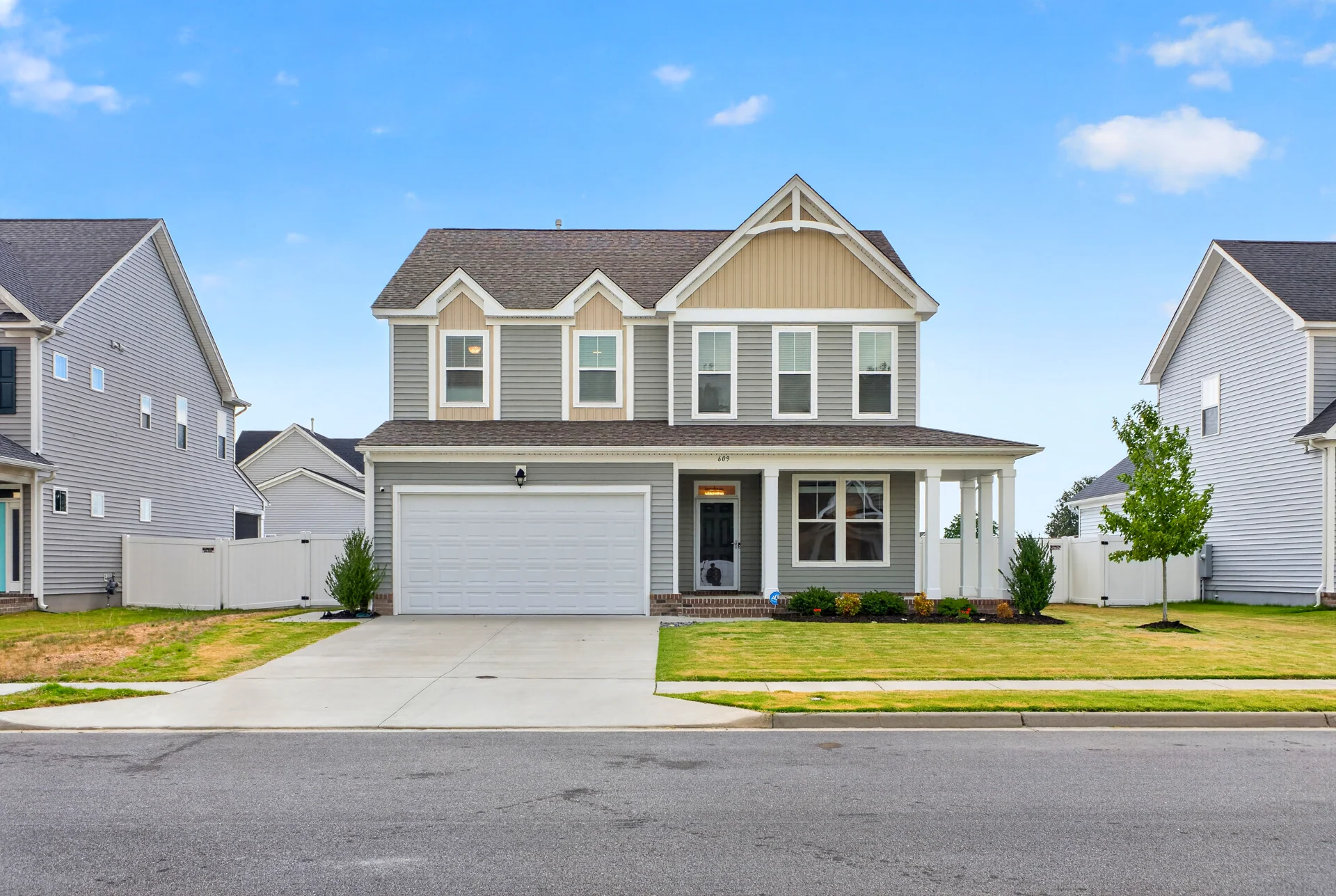 Gray two-story home with a garage and covered front porch