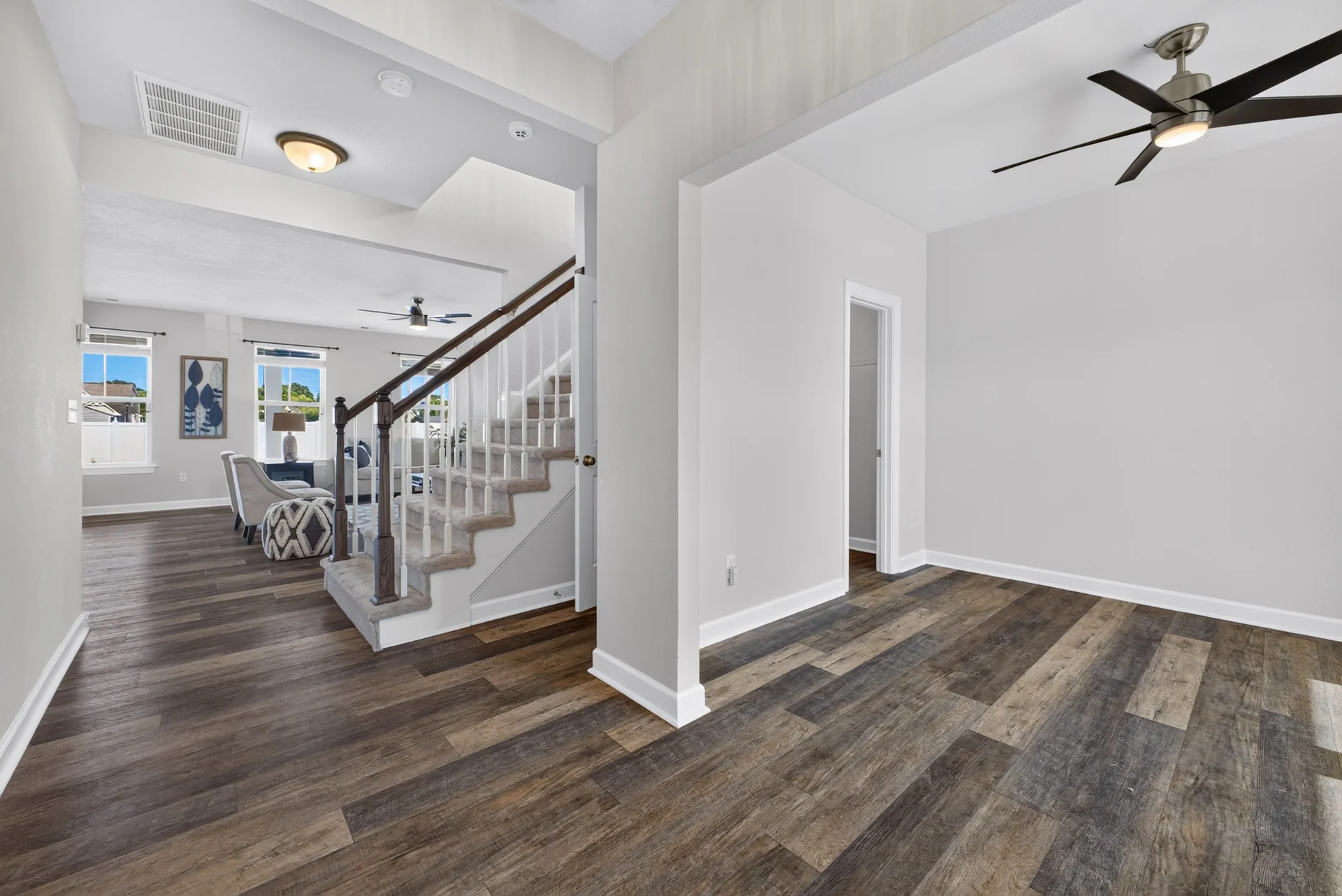 Open entry and flex space beside a white staircase