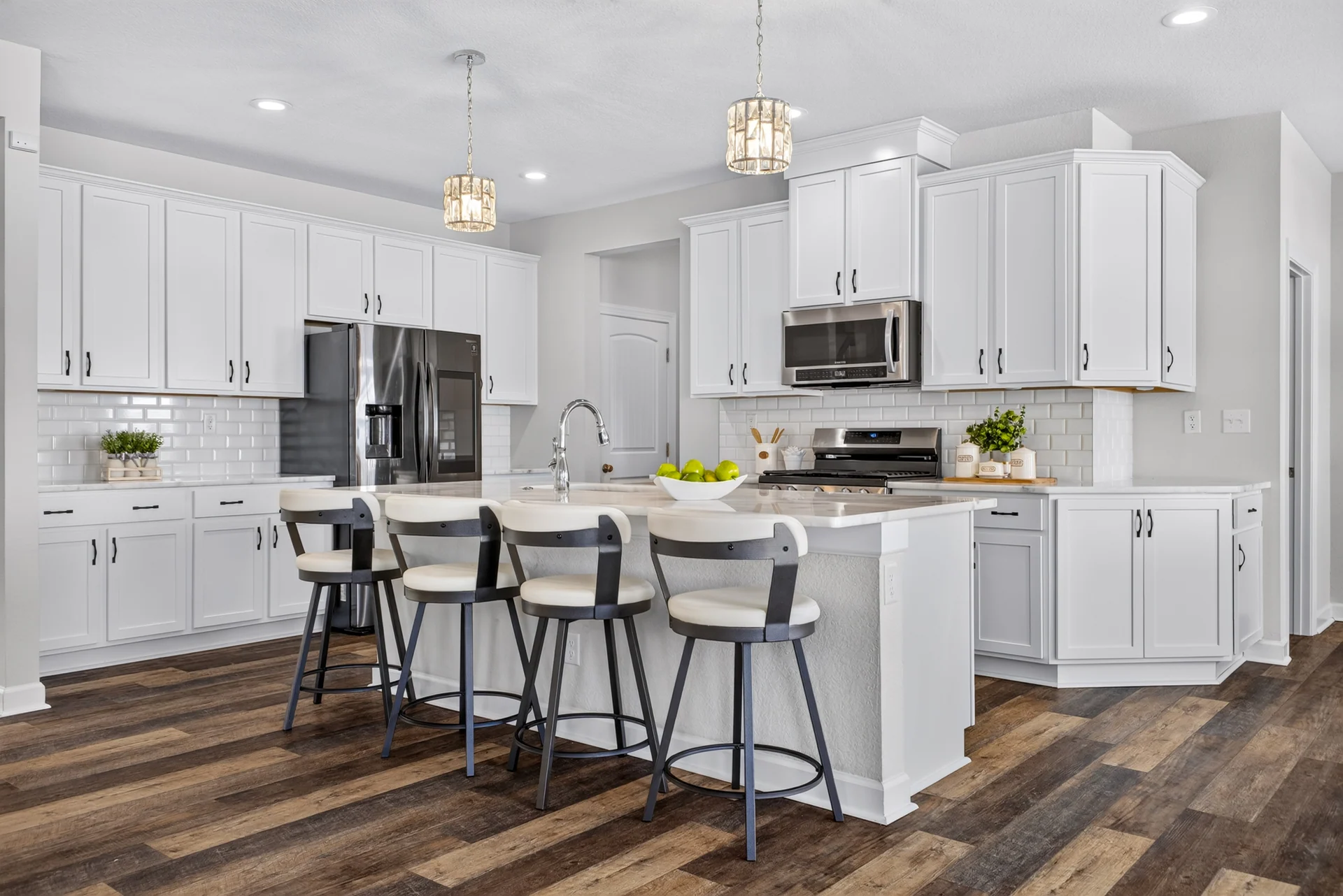White kitchen cabinets and an island with bar seating